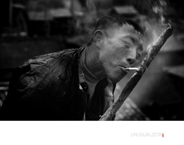 这位侗族大哥用柴火棍点烟,抽的有滋有味.