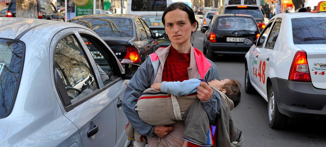 一名妇女抱着她的孩子在摩尔多瓦基希讷乌街头乞讨.