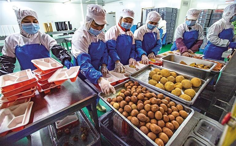 1月13日,在西安古都放心早餐工程有限公司中央厨房里,工人正在分装"