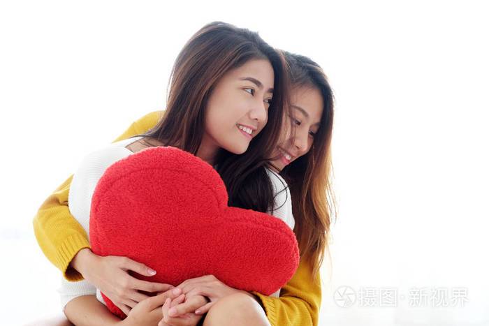 同性恋年轻可爱的亚洲女同志拥抱和持有红心脏十八