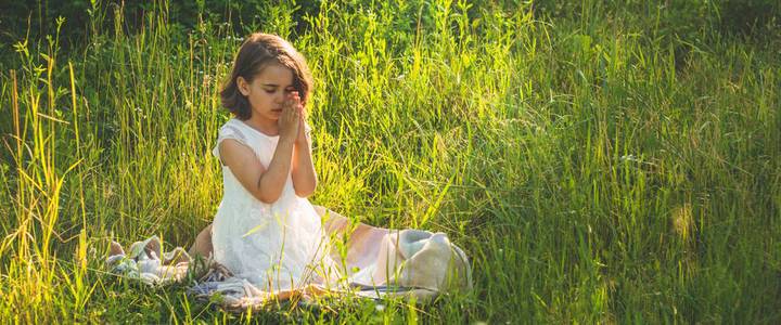 希望的田野美丽的夕阳下,小女孩闭上眼睛,在田野里祈祷.