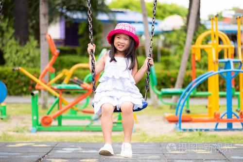 可爱的小女孩在公园里荡秋千玩得很开心.儿童游乐场