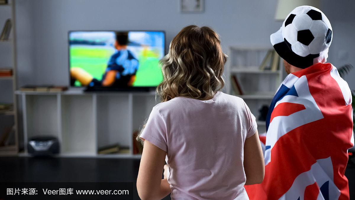 英国球迷在家通过电视观看足球比赛,支持国家队