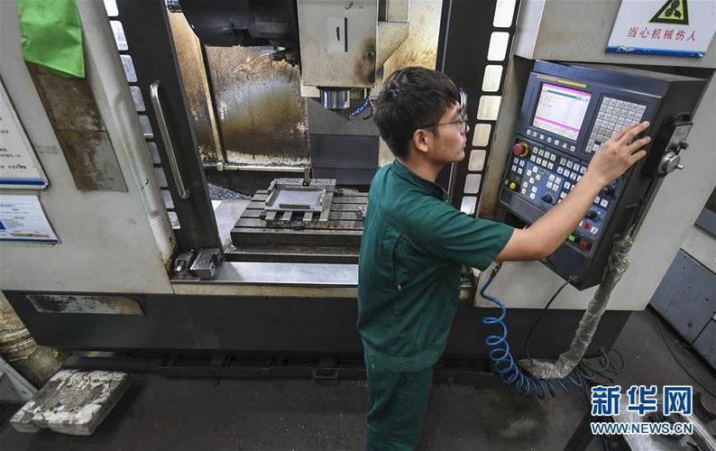 河北省安平县一家丝网机械制造企业的工人在操控数控机床加工机械零件