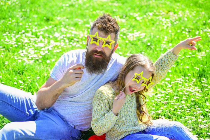 超级明星概念一家人在户外休闲父女俩坐在草地上绿色的背景孩子和爸爸