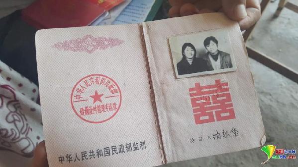 沈红伟和郑君两人的结婚证,照片上是十几年前的他们俩.