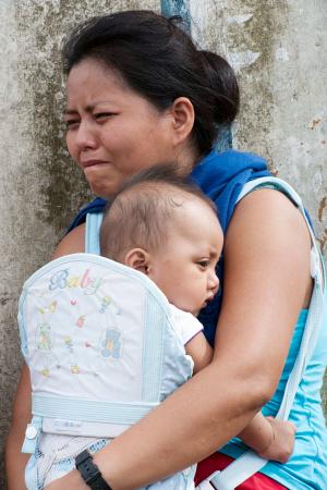 一名女子抱着婴儿哭泣.新华社发