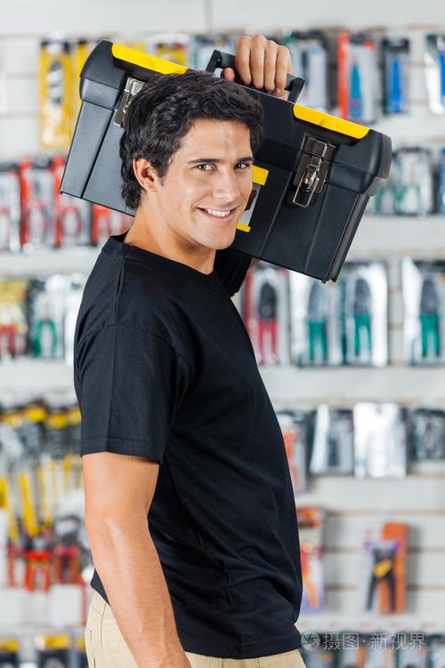 在存储区中的肩上背着工具箱的男人微笑着