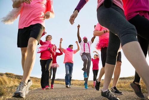 group in pink walking at charity race by hero images