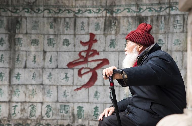 寿星|||桂林虞山公园里有一幅百寿图,恰好一位苍老的老人坐在那晒太阳