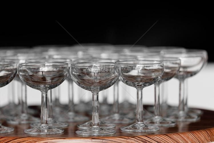 婚礼当天在木制桌边的酒杯或香槟子上有许多优雅的空酒杯或香槟子一套